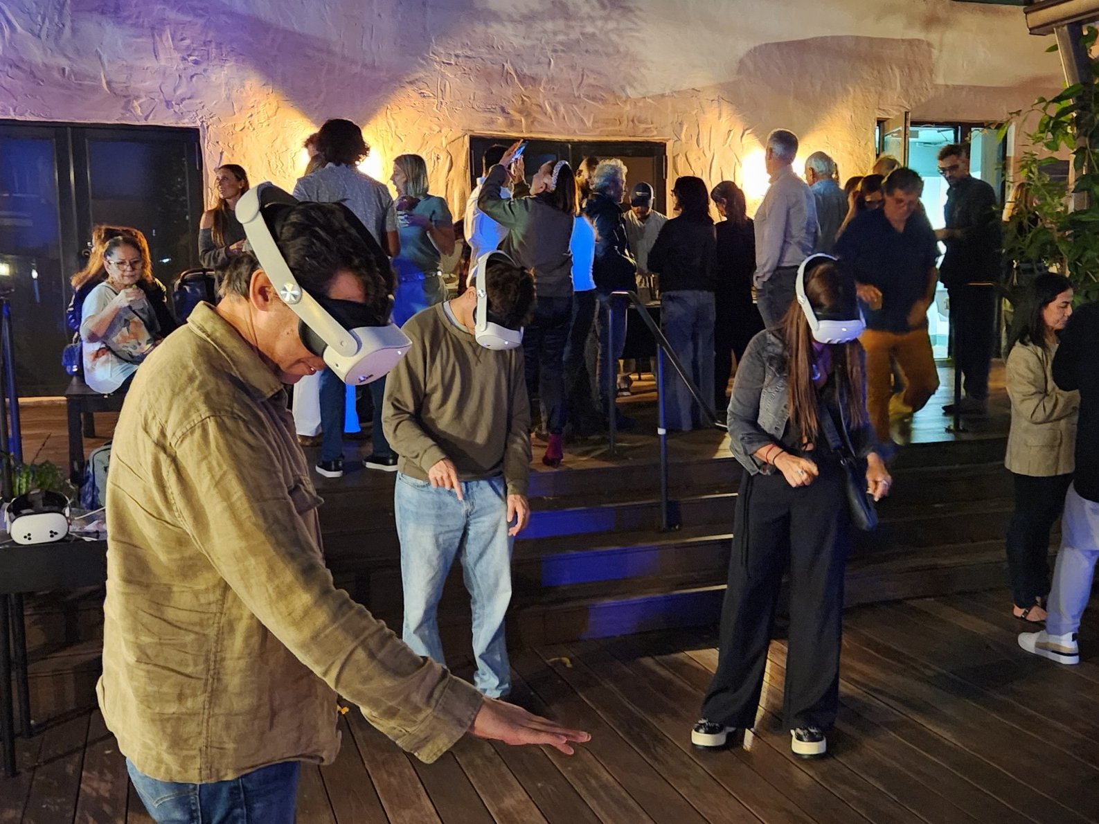 Several visitors wearing standalone headsets at once during an open-air night session